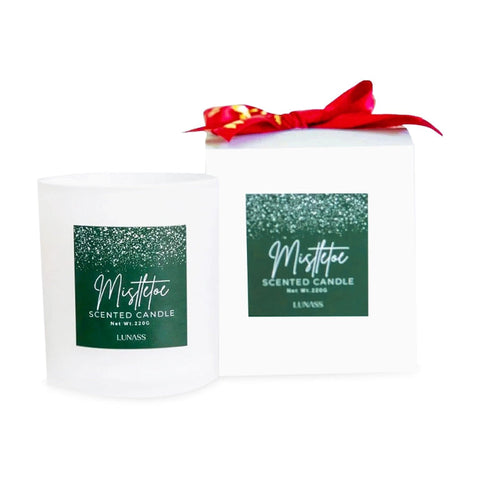 Mistletoe scented candle with a red ribbon on a white background